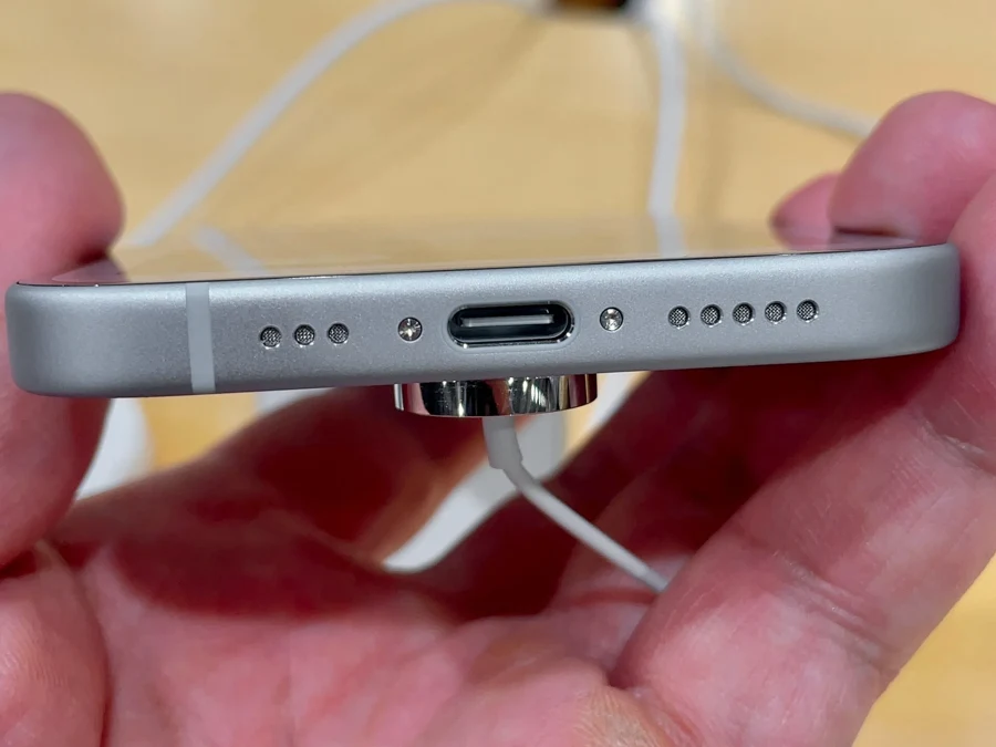 Port USB-C d'un smartphone vu de dessous, entouré des grilles de haut-parleur et de micro